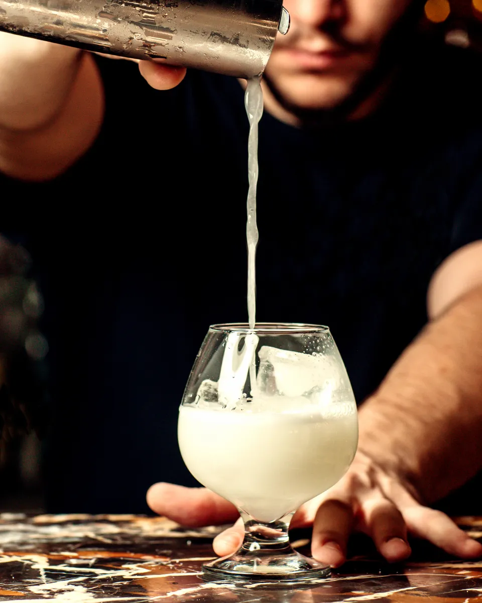 Pouring a shaken cocktail into a glass