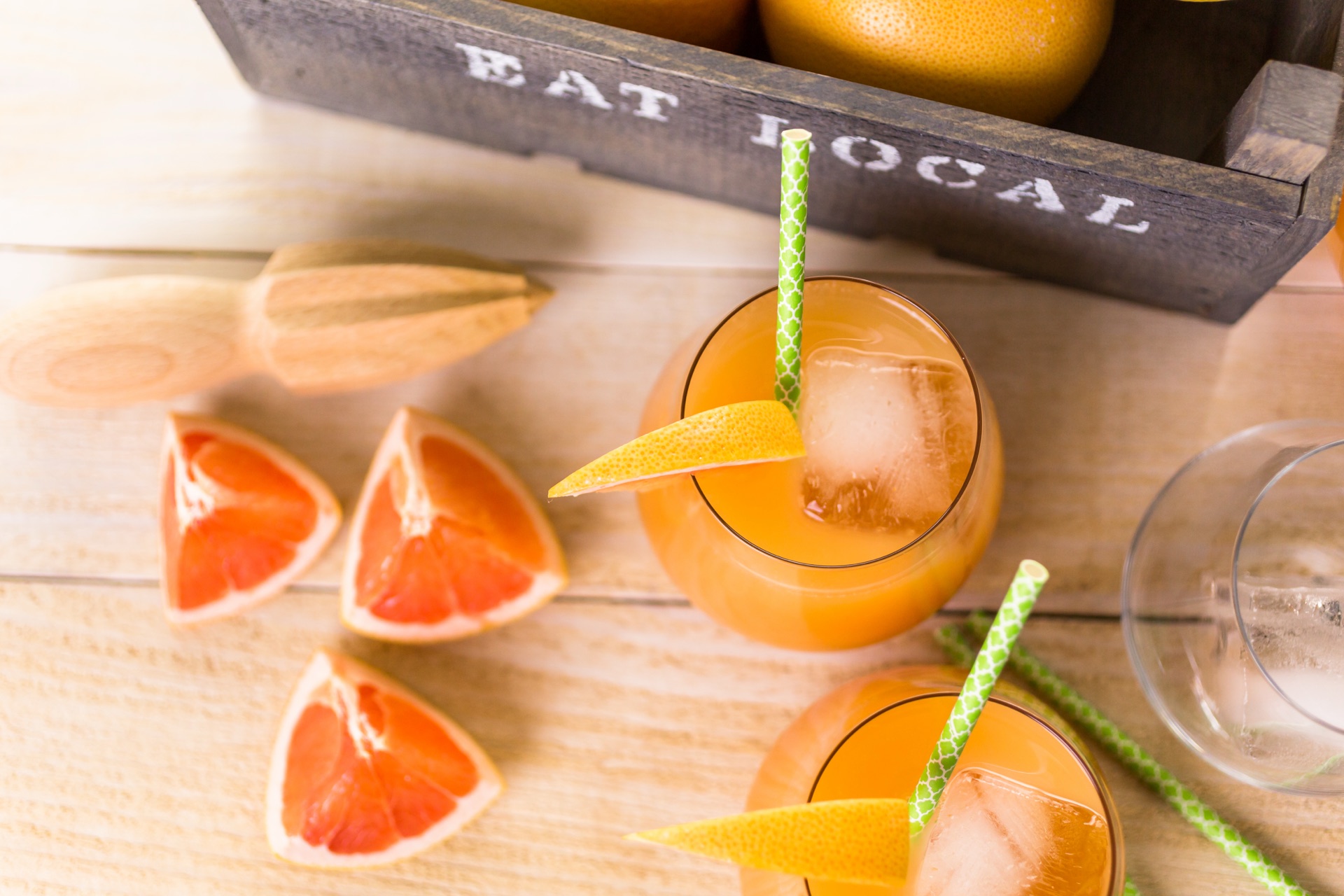 Fresh grapefruit cocktails mid-batch with a citrus juicer